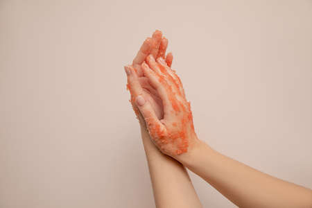 Close-up photo, female hands apply peeling pink scrub. Skin care. Healthy hand skin conceptの写真素材