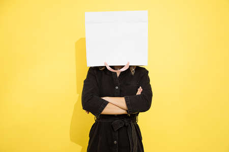 Photo of unrecognizable woman stands with shopping bag on head, stress relief with shopping,...