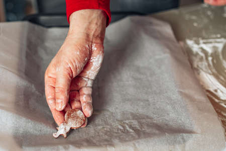 Baking concept, male chef baker's hand lays cut out cookies on baking sheet. Baking at home. Homemade baking. Dad chef. Unrecognizable personの写真素材