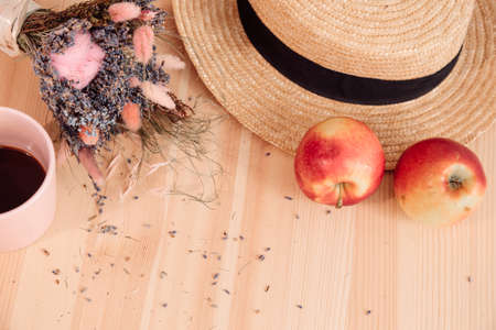 There is coffee mug on wooden surface, lavender bouquet and straw hat.Romance and Provence. Aromatherapy. Home and comfort. Lavender. Scents for home.Summer tea party. Outdoor recreation.の写真素材