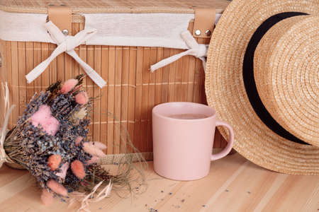On narrow wooden surface there is mug, lavender bouquet and straw hat.Romance and Provence. Aromatherapy. Home and comfort. Lavender. Scents for home.Summer tea party. Outdoor recreation.の写真素材