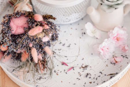 Bouquet of lavender, herbs and cotton lies on white porcelain tray and small bush roses are scattered. Romance and Provence. Aromatherapy. French charm. Lavender in bouquets. Aroma oils.SPA treatments.の写真素材