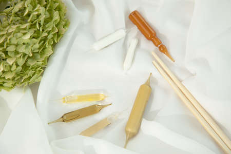Beauty treatment, Medical ampoules on white textile background, Hyaluronic acid vial for skin care....