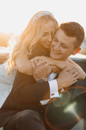 Romantic evening at sunset, bride and groom, wedding day, happiness, love. Hug, portrait, close-up. Happiness, love. Bright emotions, wedding day. Tenderness and inspiration for new life.の写真素材