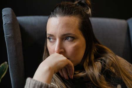 Profile of stressed woman 40 years old sitting near window thinking. female person with depressed...