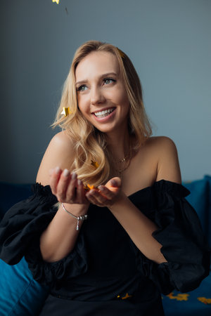Portrait of young blond woman smiling and laughing. Celebrating big holiday party at home.Decorate...