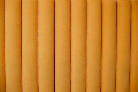 Macro background yellow velour textile. Velvet sofa with soft stripes backdrop. Couch seat, fashion...