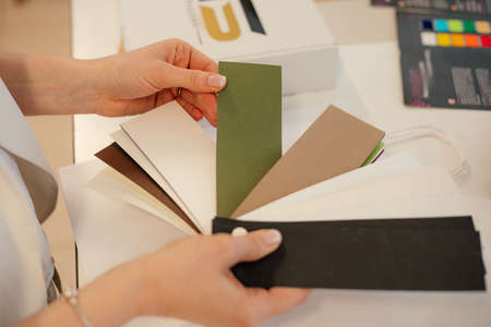 Cropped photo of woman hands holding choosing design multicolor folded envelope paper craft. Print house business offsetの写真素材