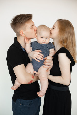 Vertical portrait of smiling calm family, woman, man, baby, hugging, spending time together....