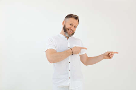 Bearded smiling businessman in white outfit on white isolated background. Showing and presenting new...
