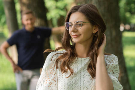 defocused man focus on woman in park among trees, happy people having fun on summer day, couple in love. Romantic momentの写真素材