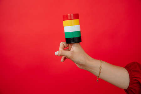 Female hand holding on finger group of roll of set of duct Insulation tape on red background