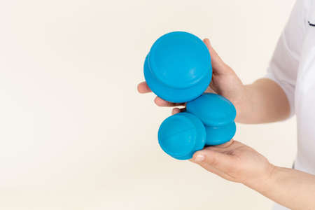 Cropped woman medical therapist hands holding blue Chinese bubble cups for vacuum anti cellulite massage. Copy space adの写真素材