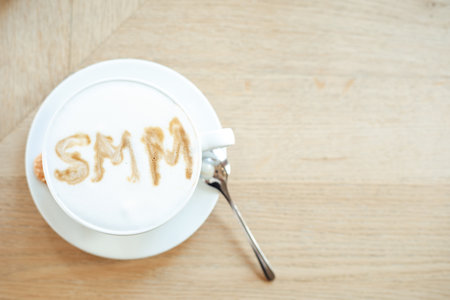 Photo top view of cup of hot flavored coffee with white foam on table, free copy space, wooden background. Social media marketing, SMM, promotion, delicious drinks in coffee house, coffee servingの写真素材