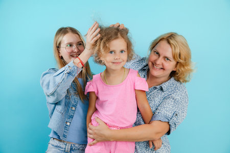 Portrait of happy family from three persons having fun on empty blue background, free copy space....