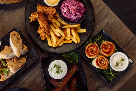 Ciabatta plate, vegetables on plate and roasted grill chicken, french fries, beet root salad, meat rolls. Table layoutの写真素材
