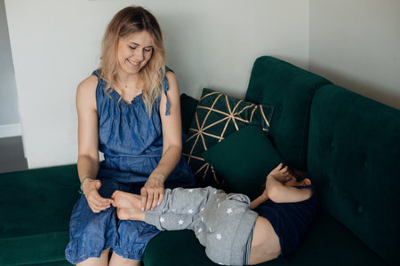 Blonde tender smiling and kind woman and little boy, son playing and embracing, have fun, tickling....
