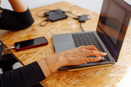Close up of female hands typing on modern laptop keyboard, young unrecognizable Caucasian women text message.の写真素材