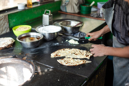 Unrecognizable man cooks food on kitchen metal surface. Dishes and kitchen equipment. Cooking....