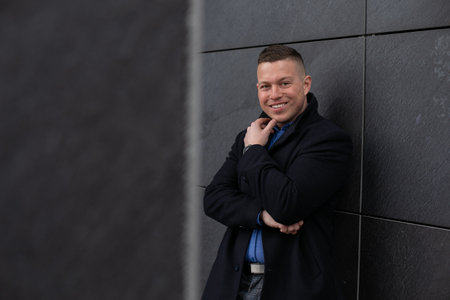 Portrait of handsome and successful man who is smiling staying and thinking about his future...