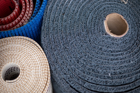 Various mats in rolls for yoga, for bath, for entrance area, for shoes are on market for sale. Household goods.の写真素材