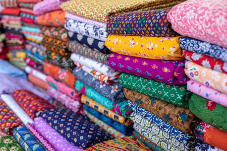 Cotton fabrics. Natural multi-colored fabrics with various patterns and patterns are in large piles in fabric store.の写真素材