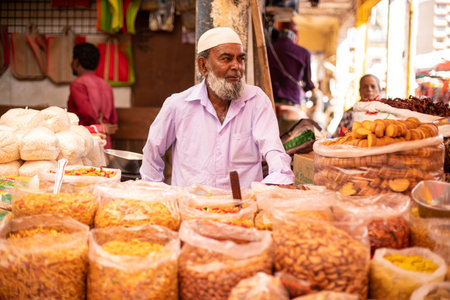 Goa, India, February 2023. . Portrait of senior Indian man seller vendor standing at stall counter in street market.のeditorial素材
