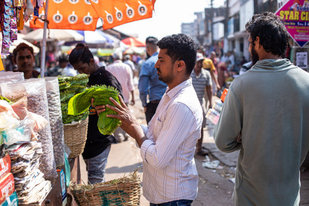 Goa, India, February 2023. Side view of young Indian man standing at counter with food choosing...