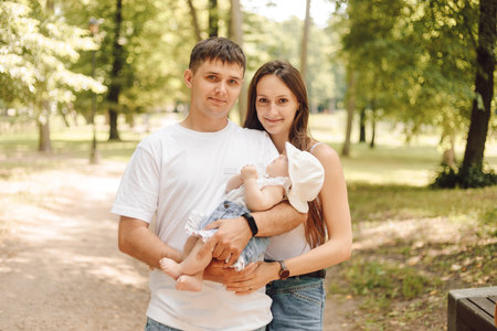 Life insurance. Lending to young family. Happy parents with their baby on summer for walk in park.の写真素材