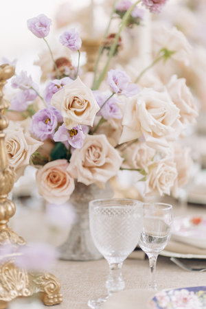 Fragment of wedding table setting, antique candlesticks, crystal, bouquets of roses in beige tones .の写真素材