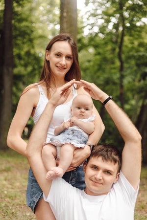 Man protection of his family. Vertical portrait of young family, mom, newborn daughter,father.
