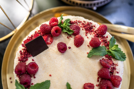 Top view. Delicious berry cake with red raspberries, strawberries, lingonberries and mint leaves.の写真素材