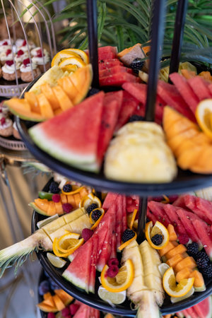 Variety of fresh organically pure fruits on buffet table at festive event. Mini snacks and goodies.の写真素材