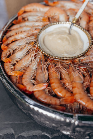Grilled shrimp with sauce on round platter in restaurant. Seafood. Healthy and proper nutrition.の写真素材