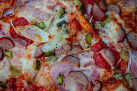 Close-up pizza with ham, cheese, olives and pickles. Pizza delivery. Recipes of Italian cuisine.の写真素材