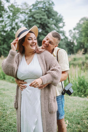 Vertical portrait of happy laughing married couple on summer day in nature. Harmonious family.の写真素材