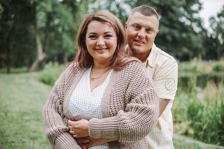 Happy married couple, husband embracing his wife, in nature on summer day. Harmonious family .の写真素材