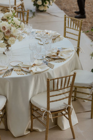 Stylish luxurious wedding table in white tones, with classic bouquets, silverware, white napkins.の写真素材
