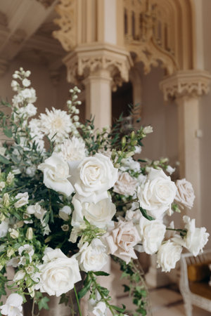 Bouquet of white roses in classic interior. Luxurious arrangement of roses at wedding ceremony.の写真素材