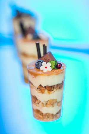 Focus of image is on glass cup with delicious dessert of whipped cream, fruits, nuts. Candy bar .の写真素材
