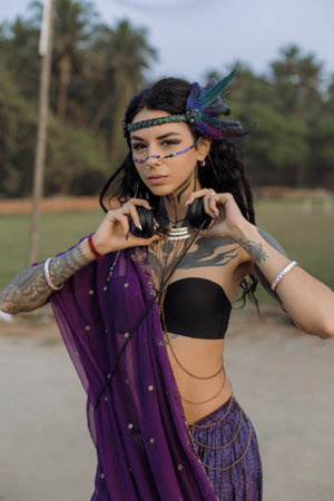 a woman in a purple saree is wearing headphones and making a heart shape with her hands