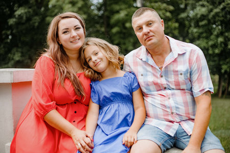 A happy family sharing a leisure event on a park bench, smiling and having funの写真素材