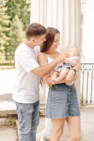 A man and a woman are happily sharing a baby in their arms at a fun eventの写真素材
