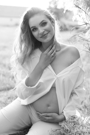 a black and white photo of a woman holding her bellyの写真素材