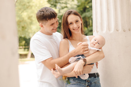 a man and a woman are holding a baby in their armsの写真素材