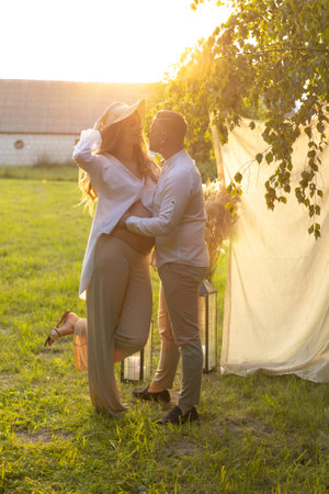 a man is holding a woman in his arms in a fieldの写真素材