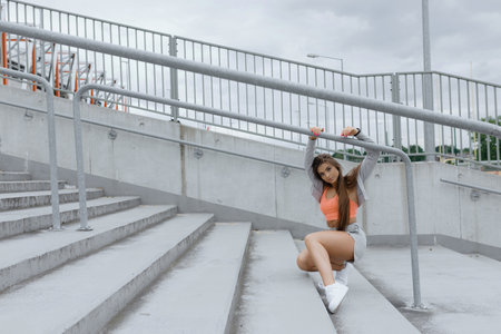 A woman is relaxing on a bridge, enjoying the sky and cloudsの写真素材