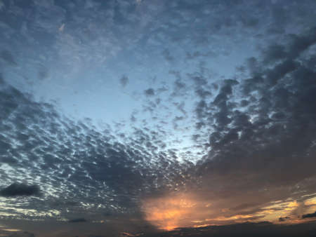 Sunset with blue sky and grey-pearl clouds, background