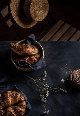 Croissants and straw hat in low keyの写真素材