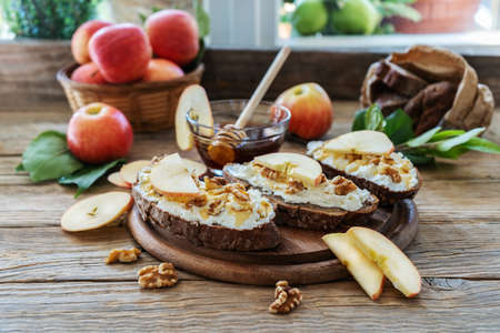Bread slices with cottage cheese, honey, apples and nutsの写真素材